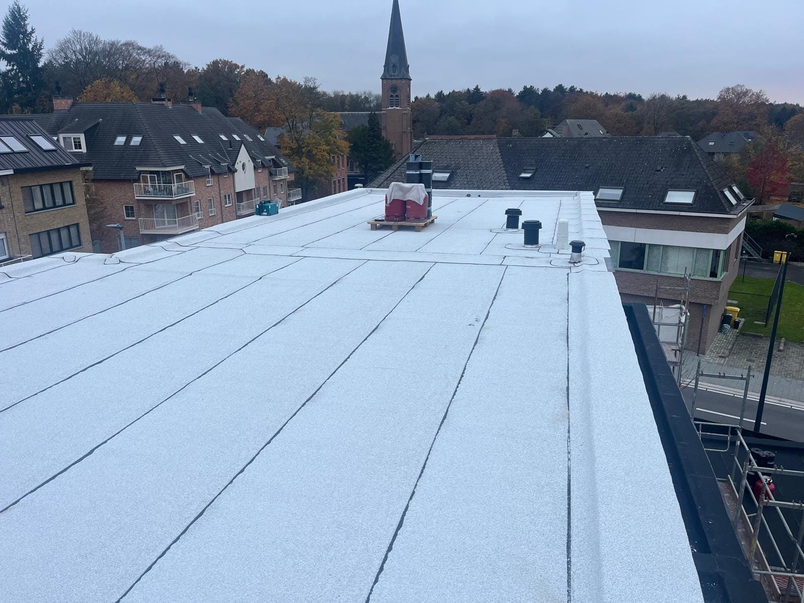 Hetzelfde dakvlak volledig afgewerkt, met dezelfde kerktoren op de achtergrond.